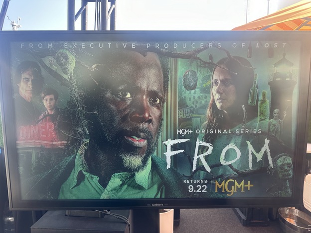 A television screen with a picture of a person and a group of peopleDescription automatically generated